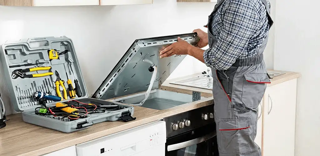 Handyman repairing a cooktop and checking wiring connections in Rochester, NY