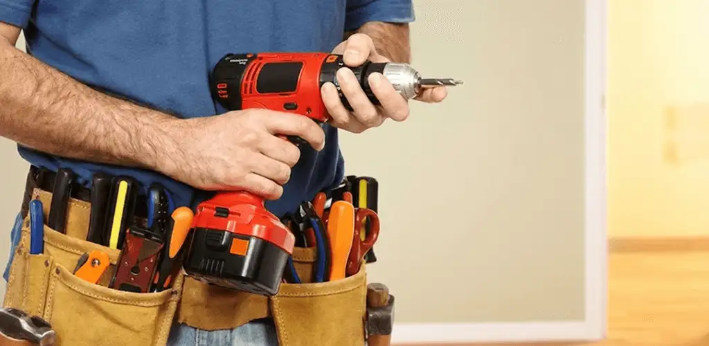 Handyman holding a power drill for home repairs and installations in Rochester, NY