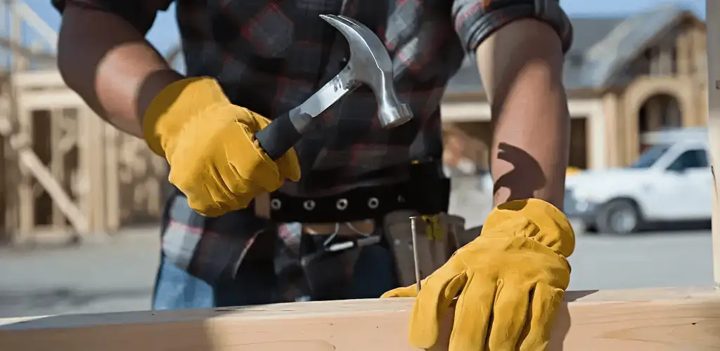 Handyman fixing wood trim with a hammer for home repairs in Rochester, NY